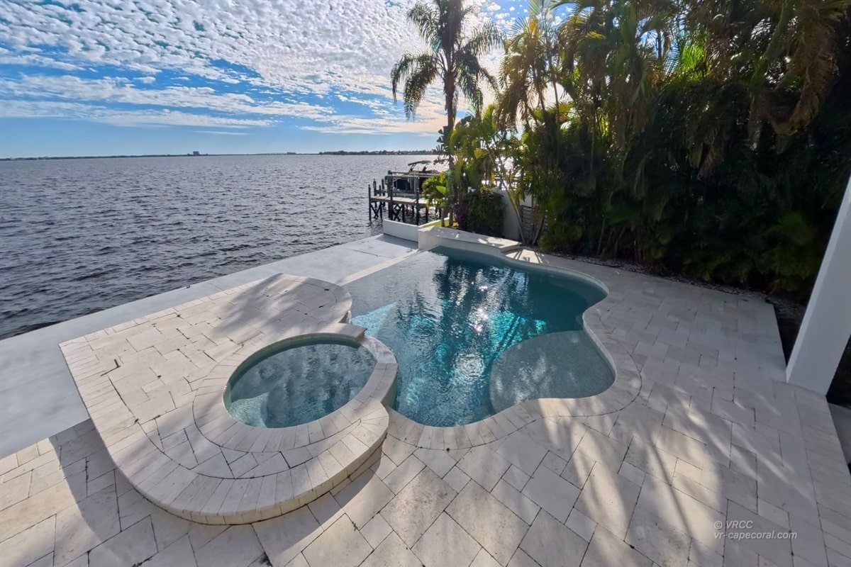 Pool overlooking ocean with palm trees