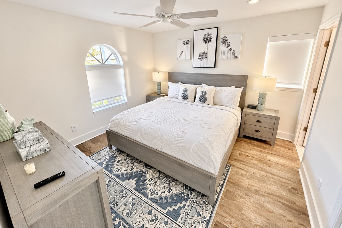 Bright coastal-style bedroom with gray bed and patterned rug