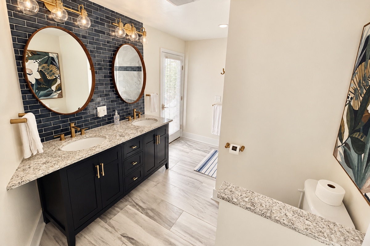 Modern bathroom with navy double vanity and round mirrors