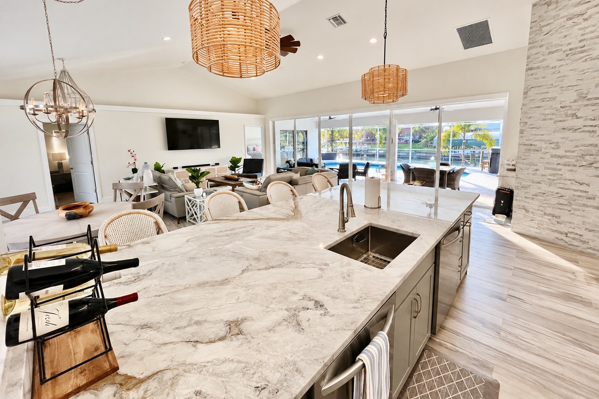 Bright open kitchen with marble island overlooking pool patio