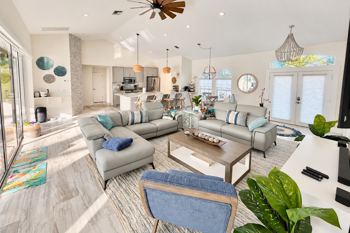 Bright open-concept living room with kitchen and coastal decor
