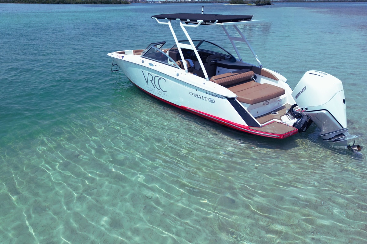 White motorboat anchored in clear turquoise shallow water