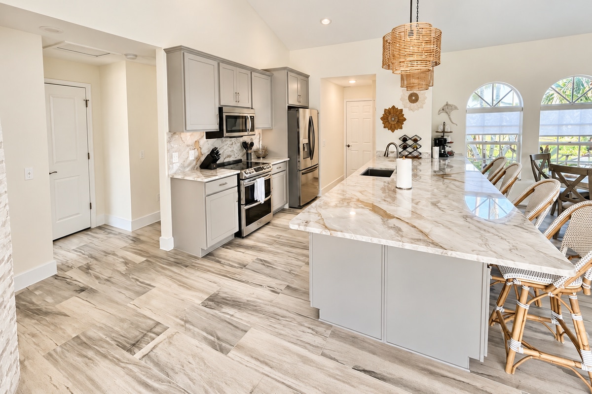 Bright modern kitchen with marble island and woven bar stools