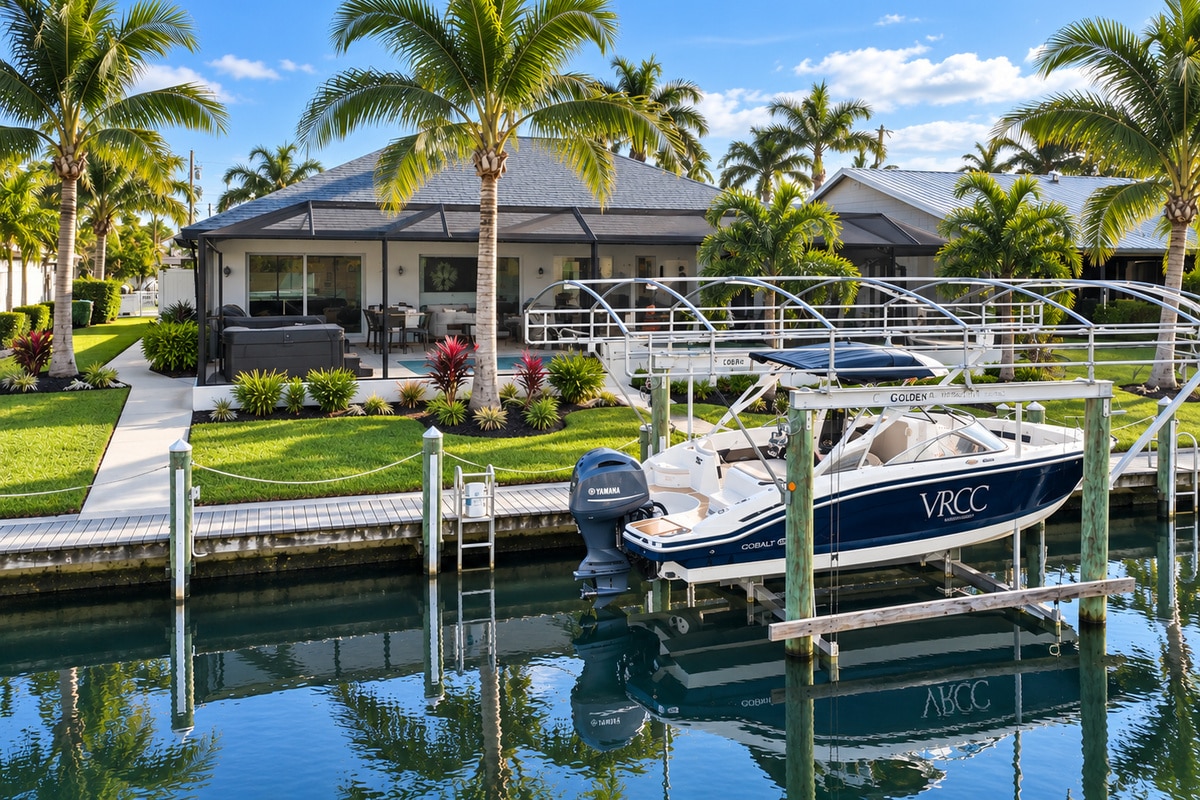 Canal-front home with boat lift and palm trees