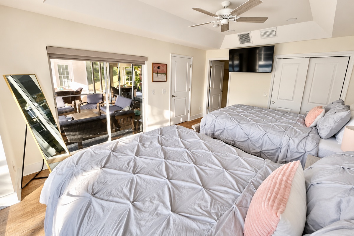 Bright bedroom with two beds and patio view